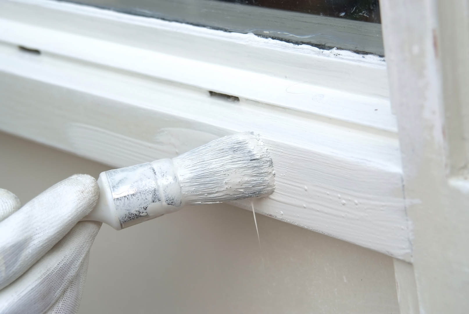A brush is on the side of a window.