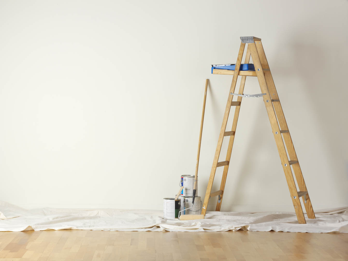 A ladder and paint can on the floor