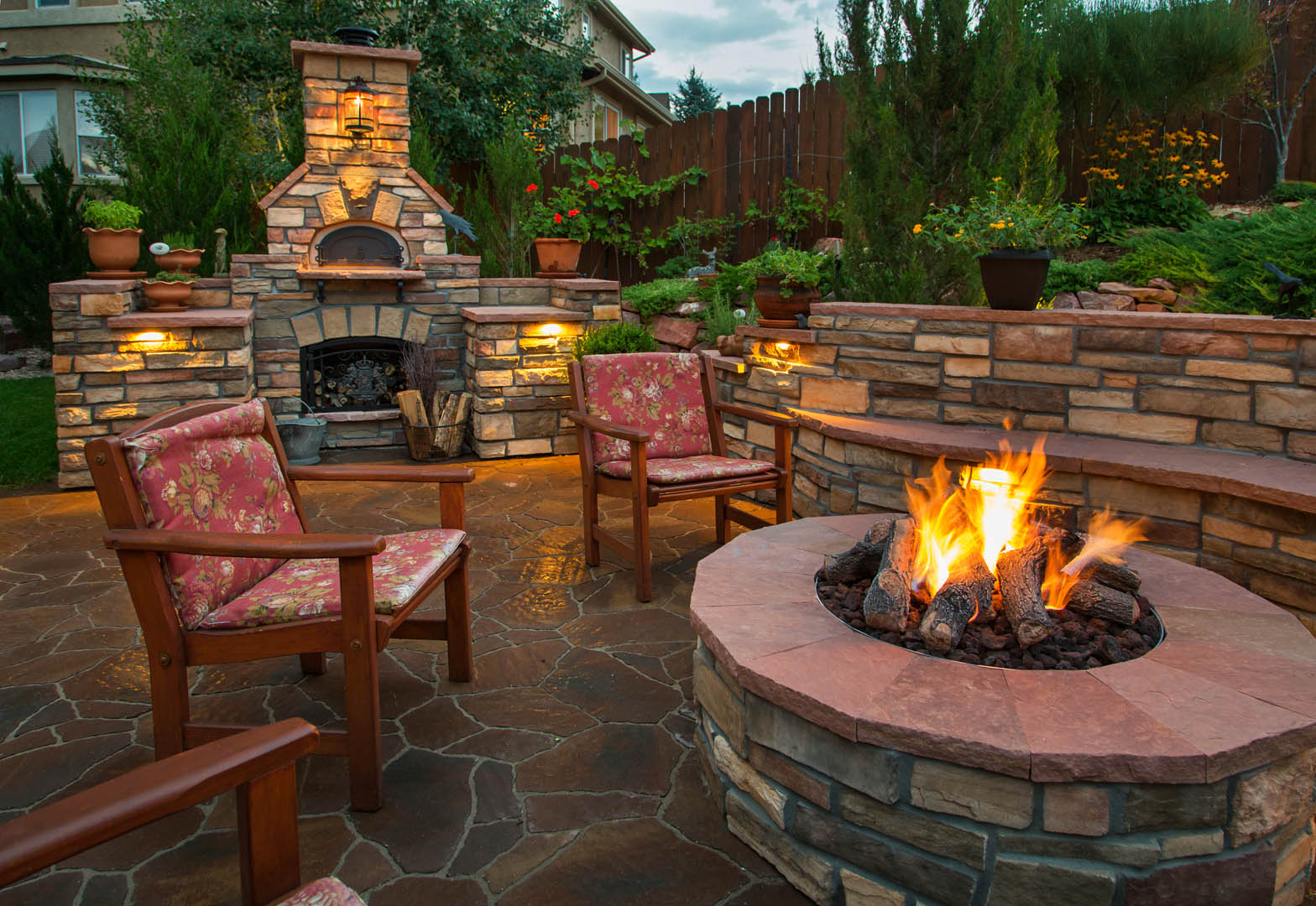 A fire pit with chairs around it and a fireplace.