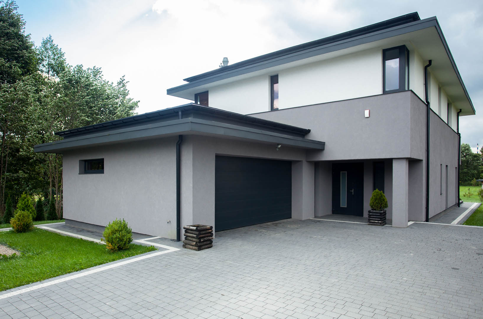 A large gray house with a black garage door.
