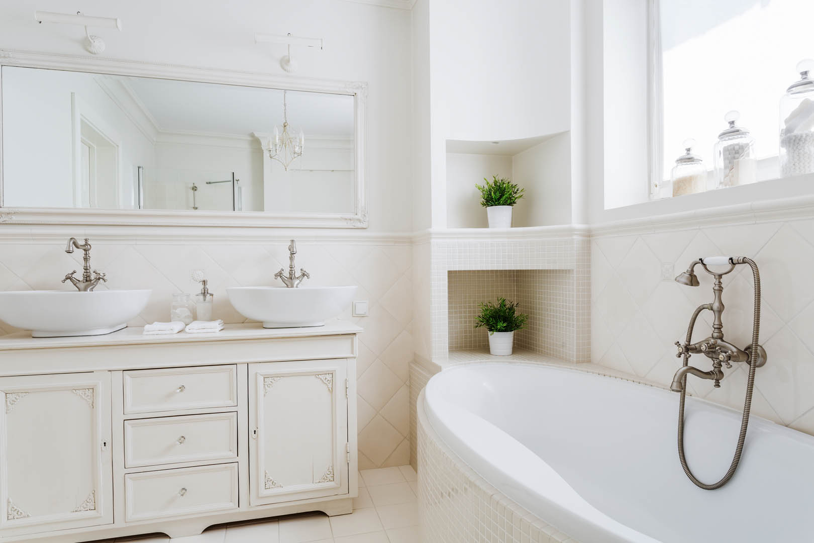A bathroom with white walls and floors, and a large tub.